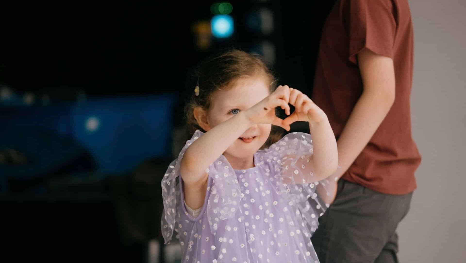 Tilly making a heart with her hands
