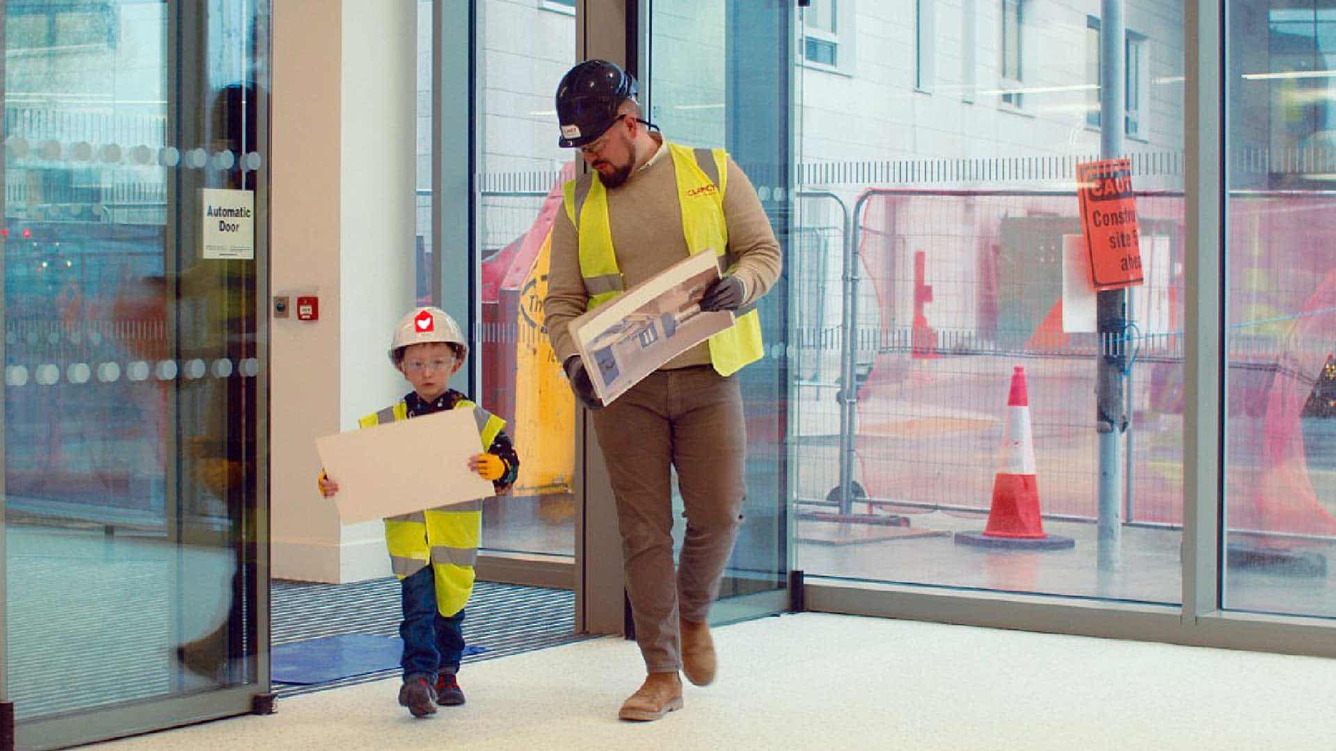 kid in construction hat with construction worker